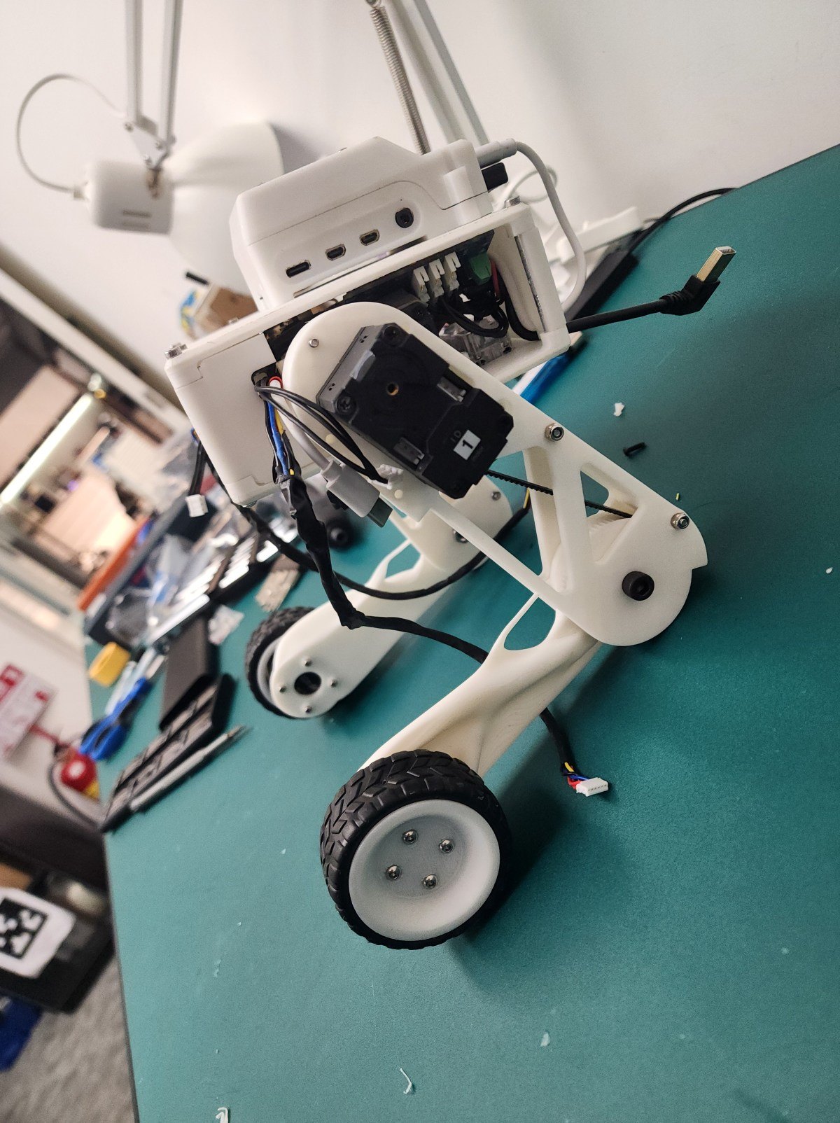 Close-up of Owen's white bipedal robot prototype on a workbench